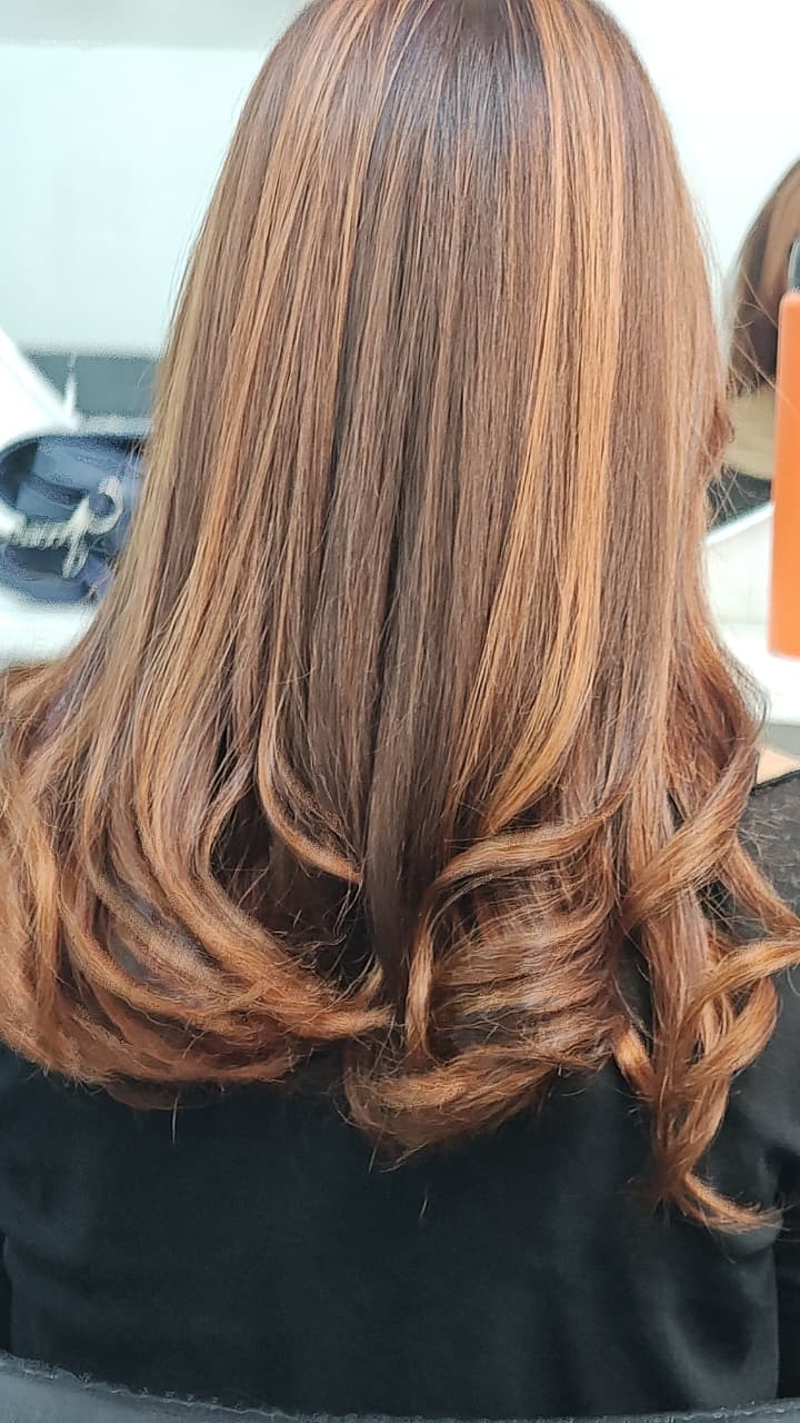 Color cobrizo con rulos y reflejos caramelo en Rosario